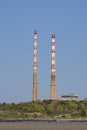 Beautiful closeup vertical bright view of iconic Poolbeg CCGT station chimneys against clear blue sky seen from Sandymount Beach Royalty Free Stock Photo