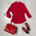 Beautiful clothing set of blouse, handbag and shoes in red colors on light wooden background. Spring fashionable outfit, casual Royalty Free Stock Photo