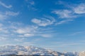 Beautiful clouds against the blue sky over the Tien Shan mountains in winter in Uzbekistan Royalty Free Stock Photo
