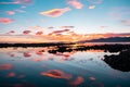 Beautiful clouds in blue sky with reflection in the water and orange sunset on the sea, Kaikoura, South Island, New Zealand Royalty Free Stock Photo