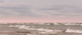 Beautiful clouds and pink glowing sky over choppy waves