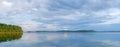 Beautiful clouds at sunset panorama of the lake with mountains on the horizon reflected on the water Royalty Free Stock Photo
