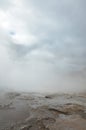 Beautiful cloudy skies with a steaming geyser in Iceland