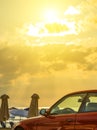 Beautiful cloudy sunset. Crete, Europe. Bright sky over car. Beach umbrellas on background Royalty Free Stock Photo