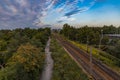 Beautiful cloudy sunset seen from long high concrete footbridge over city highway and train rails Royalty Free Stock Photo