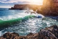 Beautiful coast of the ocean, Algarve, Portugal. Waves break against the rocks in the sun