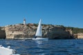 Beautiful coastal landscape seen from a boat. Cliffs, lighthouse and white yacht. Algarve, Portugal