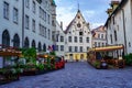 Beautiful cobbled street in the city of Tallinn with wooden benches and flowers,