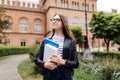Student life. Beautiful college student holding notebooks and smiling outdoors on Uni background Royalty Free Stock Photo