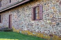 Exterior of old stone colonial American home with window shutters