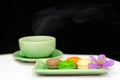 Beautiful color of macarons with hot smoke rising from a cup of tea.