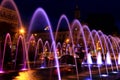 Beautiful colored dancing fountain in evening, show fountains at night against background of buildings, towers, skyscrapers, Royalty Free Stock Photo