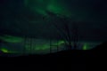 Beautiful colorful aurora borealis dancing on night sky over massive power grid structure