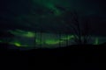 Beautiful colorful aurora borealis dancing on night sky over massive power grid structure