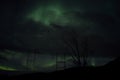 Beautiful colorful aurora borealis dancing on night sky over massive power grid structure