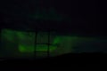 Beautiful colorful aurora borealis dancing on night sky over massive power grid structure