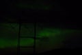 Beautiful colorful aurora borealis dancing on night sky over massive power grid structure