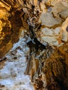Beautiful colorful cave interior with ancient stalactites and stalagmites. Vertical image Royalty Free Stock Photo