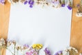 Multicolored dried flowers on wooden background, colorful limonium statice plant with copy space, blank white paper with place for