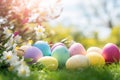 Beautiful colorful eggs and flowers in spring grass meadow over blue sky with sun Royalty Free Stock Photo