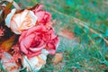 Beautiful colorful fake rose flower on the ground of green grass. Royalty Free Stock Photo