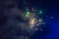 Beautiful colorful holiday fireworks in the evening sky with majestic clouds Royalty Free Stock Photo