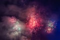 Beautiful colorful holiday fireworks in the evening sky with majestic clouds Royalty Free Stock Photo