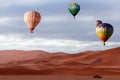 Beautiful Colorful Hot Air Baloons and dramatic clouds over the sand dunes in the desert Royalty Free Stock Photo