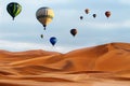 Beautiful Colorful Hot Air Baloons and dramatic clouds over the sand dunes in the desert Royalty Free Stock Photo