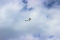 Beautiful colorful kite flying in a blue cloudy sky Royalty Free Stock Photo