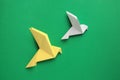Beautiful colorful origami birds on green background, flat lay Royalty Free Stock Photo