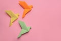 Beautiful colorful origami birds on pink background, flat lay. Space for text Royalty Free Stock Photo