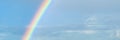 Beautiful colorful rainbow on blue sky. Banner size. Royalty Free Stock Photo