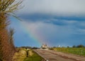 Beautiful colorful rainbow at the end of asphalt road, perspective view Royalty Free Stock Photo