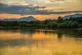 A beautiful, colorful sunset landscape with lake, mountain and forest. Natural evening scenery over the mountain lake in summer. Royalty Free Stock Photo