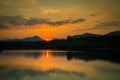 A beautiful, colorful sunset landscape with lake, mountain and forest. Natural evening scenery over the mountain lake in summer. Royalty Free Stock Photo