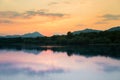 A beautiful, colorful sunset landscape with lake, mountain and forest. Natural evening scenery over the mountain lake in summer. Royalty Free Stock Photo