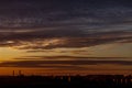 Beautiful colorful sunset over the city horizon. Magnificent clouds over the contours of buildings