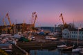 Beautiful colorful sunset port area with portal cranes, yachts and boats in Klaipeda, Lithuania. Royalty Free Stock Photo