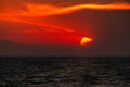 Beautiful colorful sunset at sea with dramatic clouds and mountains Royalty Free Stock Photo