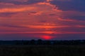 Beautiful colorful sunset. The sky shimmers in different colors. One can see the silhouettes of trees and houses Royalty Free Stock Photo