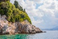 Beautiful and colorful view of rock coastline and crystal, blue sea on sunny day. Small stone cliff ideal for jump into