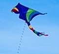 A beautiful, colourful stunt kite, in the blue sky, high up in the wind