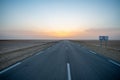 Beautiful colourful sunset over endless empty road in middle of desert. Asphalt highway in Tunisia, North Africa.