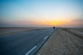 Beautiful colourful sunset over endless empty road in middle of desert. Asphalt highway in Tunisia, North Africa. Royalty Free Stock Photo