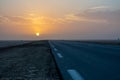 Beautiful colourful sunset over endless empty road in middle of desert. Asphalt highway in Tunisia, North Africa. Royalty Free Stock Photo