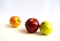 A beautiful combination of two fresh green and red apples leaning together and a shiny apple on a white background