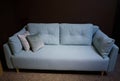 Beautiful comfortable minimalist stylish turquoise sofa with patterned cushions in the furniture store exposition center. Home