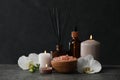 Beautiful composition with burning candles and different spa products on dark grey table Royalty Free Stock Photo