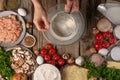 A beautiful composition of ingredients: flour, mushrooms, herbs, tomatoes, eggs, spices. The chef prepares pizza, ravioli, pie.